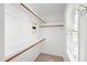 Walk-in closet features white walls, shelving, wooden support poles and neutral carpet at 213 Beechtree Dr, Cary, NC 27513