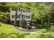 Charming two-story home with light yellow siding, black shutters, brick foundation and lush landscaping at 213 Beechtree Dr, Cary, NC 27513