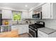 Kitchen featuring white cabinets, stainless steel appliances, and mosaic tile backsplash at 213 Beechtree Dr, Cary, NC 27513