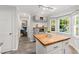 Open kitchen featuring white cabinets, an island with wood countertop, and large windows at 213 Beechtree Dr, Cary, NC 27513