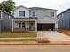 Two-story home features gray siding, dark shutters, a large garage, and a well-manicured lawn at 2214 Cherry Creek Rd, Haw River, NC 27258