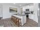 Modern kitchen featuring white cabinets, stainless steel appliances, a central island, and wood floors at 2736 Luxborough Ln, Mebane, NC 27302