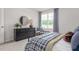 Bright bedroom with a dresser, round mirror, and a window bringing in natural light at 2739 Luxborough Ln, Mebane, NC 27302