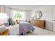 Bright bedroom featuring a bed with stylish bedding, dresser, and a large window at 2739 Luxborough Ln, Mebane, NC 27302