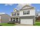 Charming two-story home with a brick and siding exterior, a two-car garage, and a well-manicured front lawn at 2739 Luxborough Ln, Mebane, NC 27302
