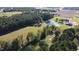 Expansive aerial view of property featuring a pond, barn, and surrounding fields and trees at 2747 Beasley, Benson, NC 27504