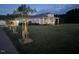 Dusk view of a cozy home with front porch, manicured lawn and young trees at 2747 Beasley, Benson, NC 27504
