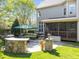 Expansive backyard patio with stone bar, green umbrella, and screened porch perfect for outdoor entertaining at 2817 Peachleaf St, Raleigh, NC 27614