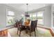 Bright dining room featuring hardwood floors, large windows, and a modern chandelier at 2817 Peachleaf St, Raleigh, NC 27614