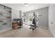 Bright workout room includes a multi-station machine, work space with built-in shelving, and a neutral color scheme at 2817 Peachleaf St, Raleigh, NC 27614