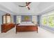 Beautiful main bedroom with a tray ceiling, ceiling fan, lots of natural light, and traditional wood furniture at 2817 Peachleaf St, Raleigh, NC 27614