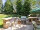 Built-in stone outdoor kitchen, bar seating, stainless steel grill, and backyard views for outdoor dining and entertainment at 2817 Peachleaf St, Raleigh, NC 27614