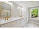 Bright bathroom with double vanity, white cabinets, gold hardware, and marble tile floor at 313 Crown Oaks Dr, Raleigh, NC 27615