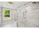 Bathroom featuring frameless glass shower, marble tile, and chandelier at 313 Crown Oaks Dr, Raleigh, NC 27615