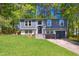 Charming two-story home featuring a brick-lined staircase, a modern garage door and a lush, green front lawn at 313 Crown Oaks Dr, Raleigh, NC 27615