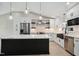 Modern kitchen with marble countertop island, stainless appliances, white cabinetry, pendant lights, and hardwood floors at 313 Crown Oaks Dr, Raleigh, NC 27615