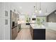 Modern kitchen with marble countertop island, stainless appliances, white cabinetry, pendant lights, and hardwood floors at 313 Crown Oaks Dr, Raleigh, NC 27615