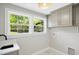 Laundry room features natural light, gray cabinets, and marble tile at 313 Crown Oaks Dr, Raleigh, NC 27615