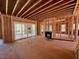 Unfinished living room with visible framing, fireplace, sliding glass doors leading to the outdoor deck at 348 Inspiration Way, Fuquay Varina, NC 27526