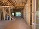 Unfinished living room with visible framing, staircase, and natural light streaming through the windows at 348 Inspiration Way, Fuquay Varina, NC 27526