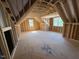 Unfinished bonus room featuring framed walls, windows, and natural light under the eaves at 348 Inspiration Way, Fuquay Varina, NC 27526