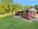 View of a fenced backyard with a brick house and small patio at 3504 Crofton Ct, Raleigh, NC 27604