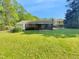 Spacious backyard features a lush green lawn, a covered patio, and a charming brick house at 3504 Crofton Ct, Raleigh, NC 27604