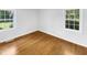 Light-filled bedroom with hardwood flooring and two large windows allowing natural light to fill the space at 3504 Crofton Ct, Raleigh, NC 27604