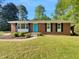 Charming brick home with a well-maintained lawn, a bright blue front door, and lush landscaping at 3504 Crofton Ct, Raleigh, NC 27604