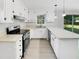 Well-lit kitchen with white cabinets, modern appliances, and a countertop that doubles as a breakfast bar at 3504 Crofton Ct, Raleigh, NC 27604