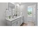 Modern bathroom featuring double sinks and a large mirror, with a door to the side at 3715 Rosebush Dr, Zebulon, NC 27597