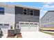 Back exterior view of modern townhomes with garage doors, siding, and an AC unit at 3715 Rosebush Dr, Zebulon, NC 27597