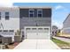 Back exterior view of a modern townhome with a two-car garage and contemporary siding at 3715 Rosebush Dr, Zebulon, NC 27597