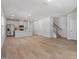 Open-concept living room with wood floors leading to kitchen and staircase at 3715 Rosebush Dr, Zebulon, NC 27597