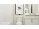 Modern bathroom featuring a toilet, white vanity with storage, mirror, and minimalist decor with a gray accent at 4008 Shadbush St, Raleigh, NC 27616