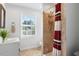 Bright bathroom featuring a vanity, toilet and tile shower with a shower curtain at 402 Vatersay Dr, Apex, NC 27502