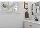 Bright bathroom features a white vanity, modern faucet, framed mirror, and natural light from the window at 402 Vatersay Dr, Apex, NC 27502
