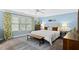 Light-filled bedroom with blue walls, crown molding, and a plush queen-sized bed with a wooden bench at 402 Vatersay Dr, Apex, NC 27502