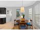 Bright dining area features a modern light fixture, a round wood table with seating for four, and serene wall art at 402 Vatersay Dr, Apex, NC 27502