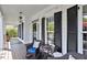 Charming covered front porch with black shutters, inviting seating, and a wreath-adorned door at 402 Vatersay Dr, Apex, NC 27502