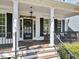 Charming front porch with classic columns, black shutters, and inviting seating area at 402 Vatersay Dr, Apex, NC 27502
