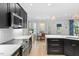 Open concept kitchen with black cabinets, stainless appliances, white subway tile and view of dining area at 402 Vatersay Dr, Apex, NC 27502