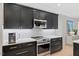 Stylish kitchen showcasing sleek black cabinets, stainless steel appliances, and white subway tile at 402 Vatersay Dr, Apex, NC 27502