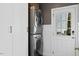 Convenient laundry room with stacked washer and dryer, storage cabinets, and a door to the outdoors at 402 Vatersay Dr, Apex, NC 27502