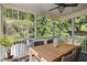 Inviting screened-in porch with ceiling fan and wood table surrounded by greenery at 402 Vatersay Dr, Apex, NC 27502