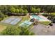 A high angle view showcases tennis courts and a swimming pool in a lush community at 4936 Liverpool Ln, Raleigh, NC 27604