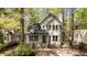 Charming two-story home with a covered front porch and mature trees surrounding the property at 4936 Liverpool Ln, Raleigh, NC 27604