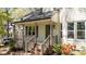 Inviting covered front porch with brick steps and decorative landscaping at the home's entrance at 4936 Liverpool Ln, Raleigh, NC 27604