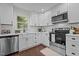 Modern kitchen with stainless steel appliances, white cabinets, and subway tile backsplash at 4936 Liverpool Ln, Raleigh, NC 27604