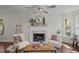 Cozy living room with a fireplace, wood floors, and a ceiling fan at 4936 Liverpool Ln, Raleigh, NC 27604
